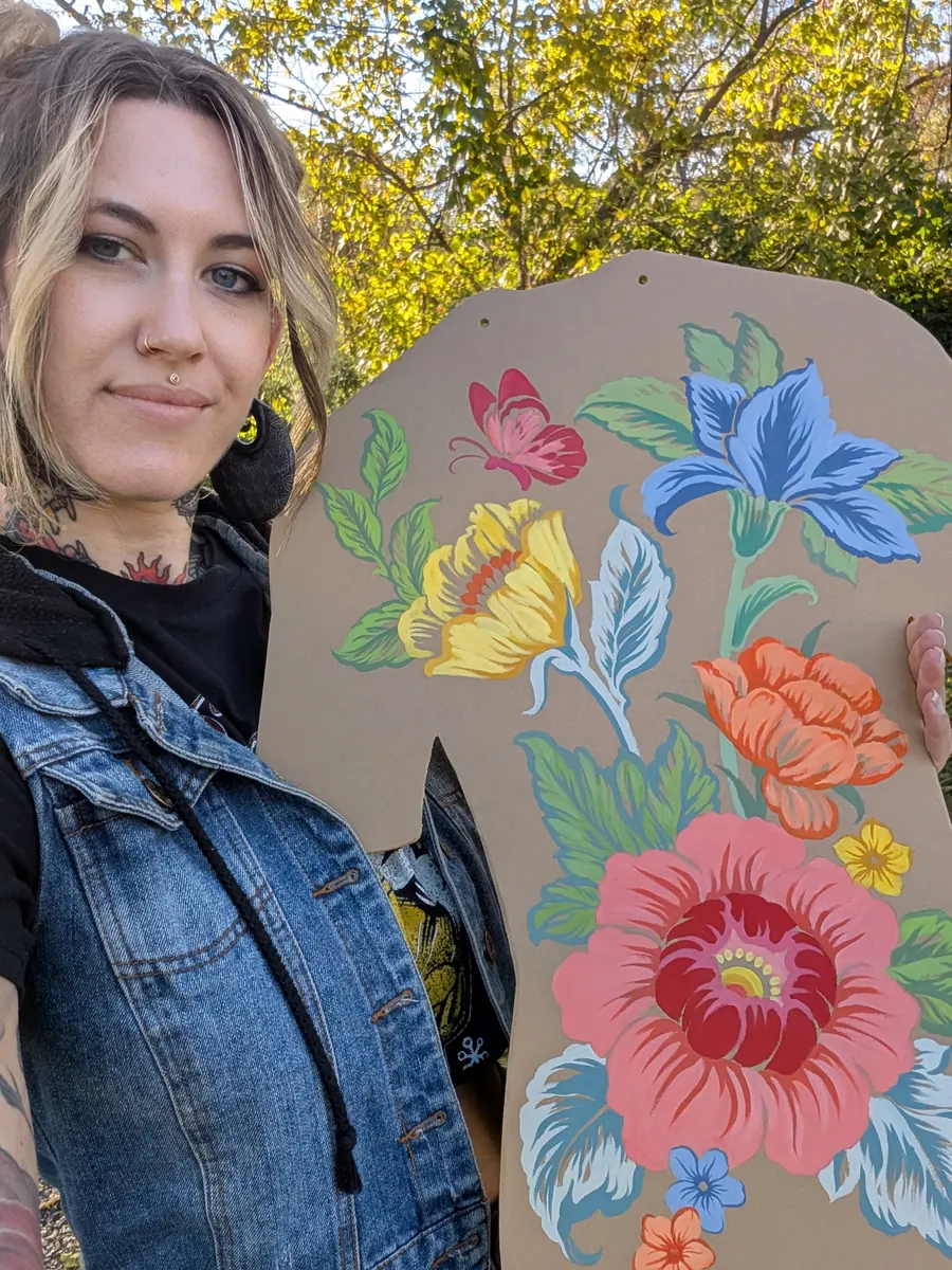 English Cousins holding a hand-painted floral backsuit panel