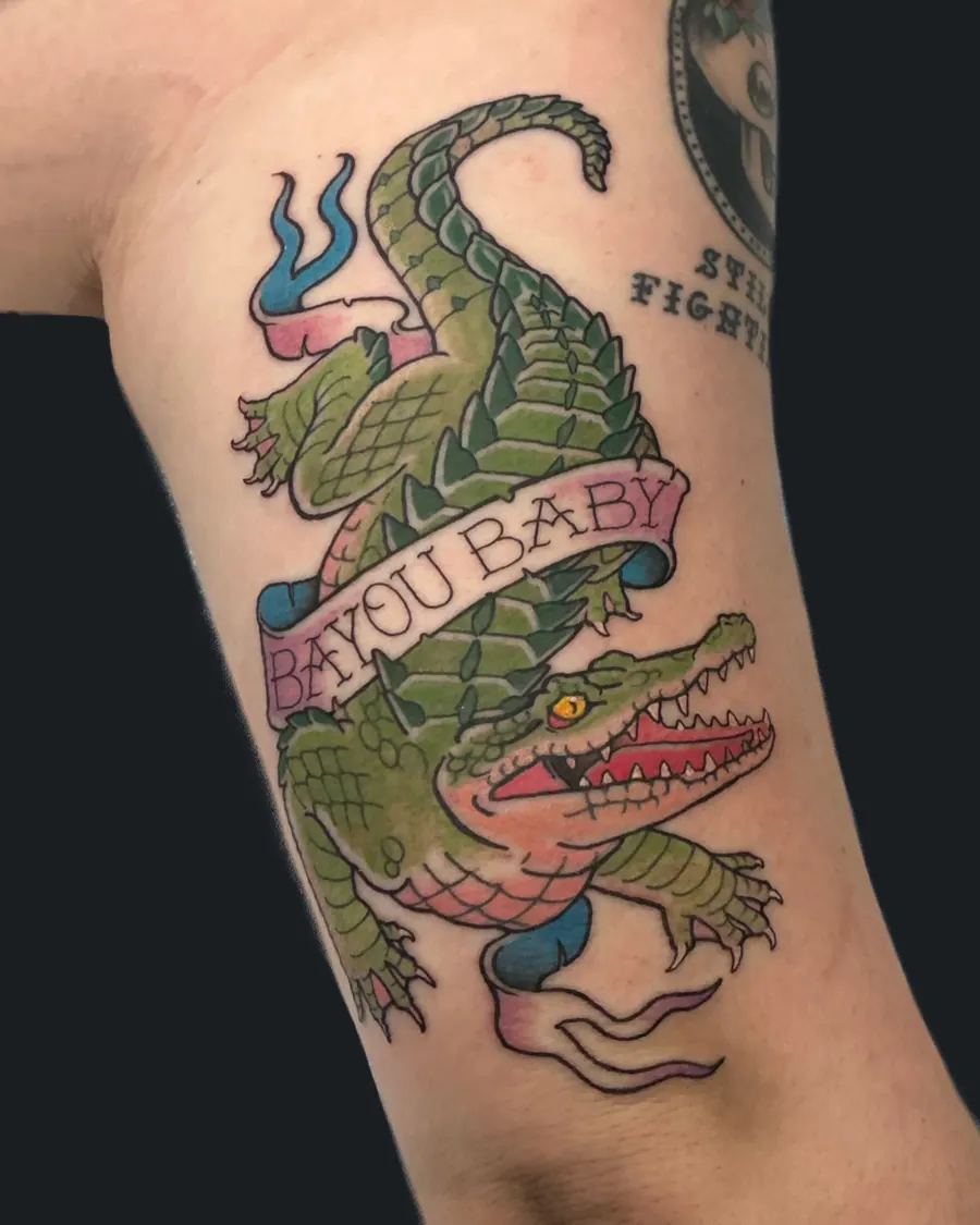 Traditional alligator tattoo with a Bayou Baby banner on the ribs by English Cousins, Nashville