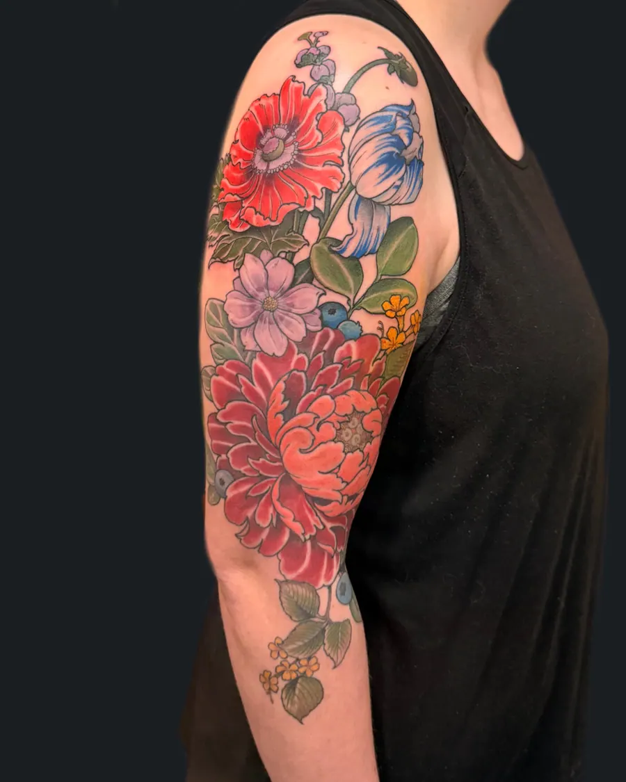 Illustrative floral half sleeve tattoo with red poppy, blue tulip, pink cosmos, peony, and blueberries by English Cousins, Nashville