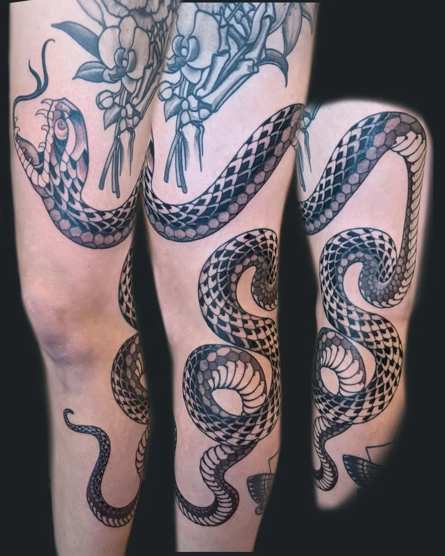 Black and gray snake tattoo wrapping around the knee and lower leg by English Cousins, Nashville