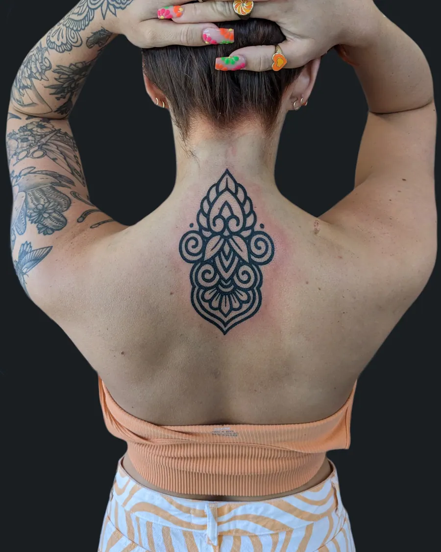 Ornamental blackwork tattoo on the back of the neck and upper back by English Cousins, Nashville
