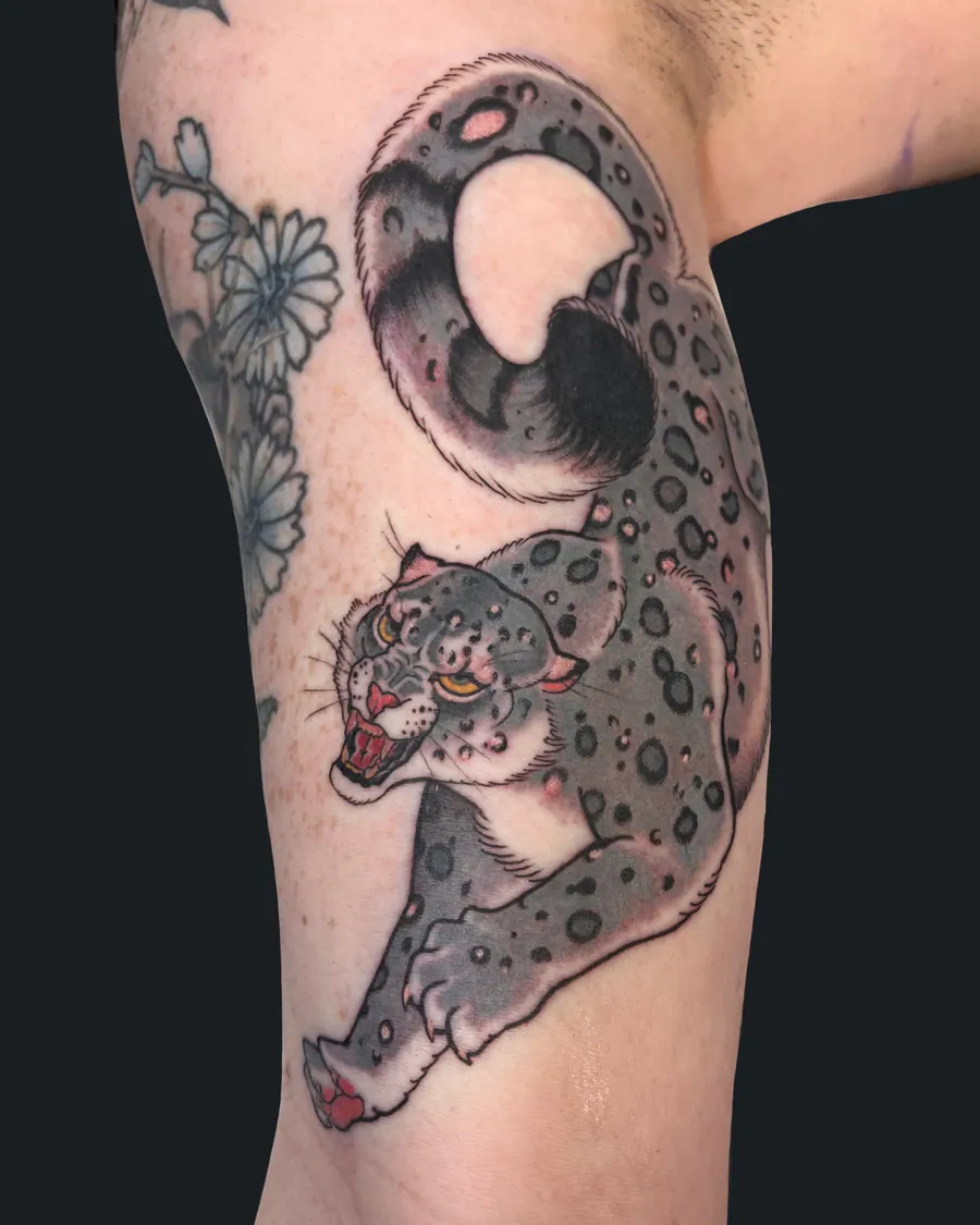 Neotraditional roaring snow leopard tattoo on the upper arm by English Cousins, Nashville