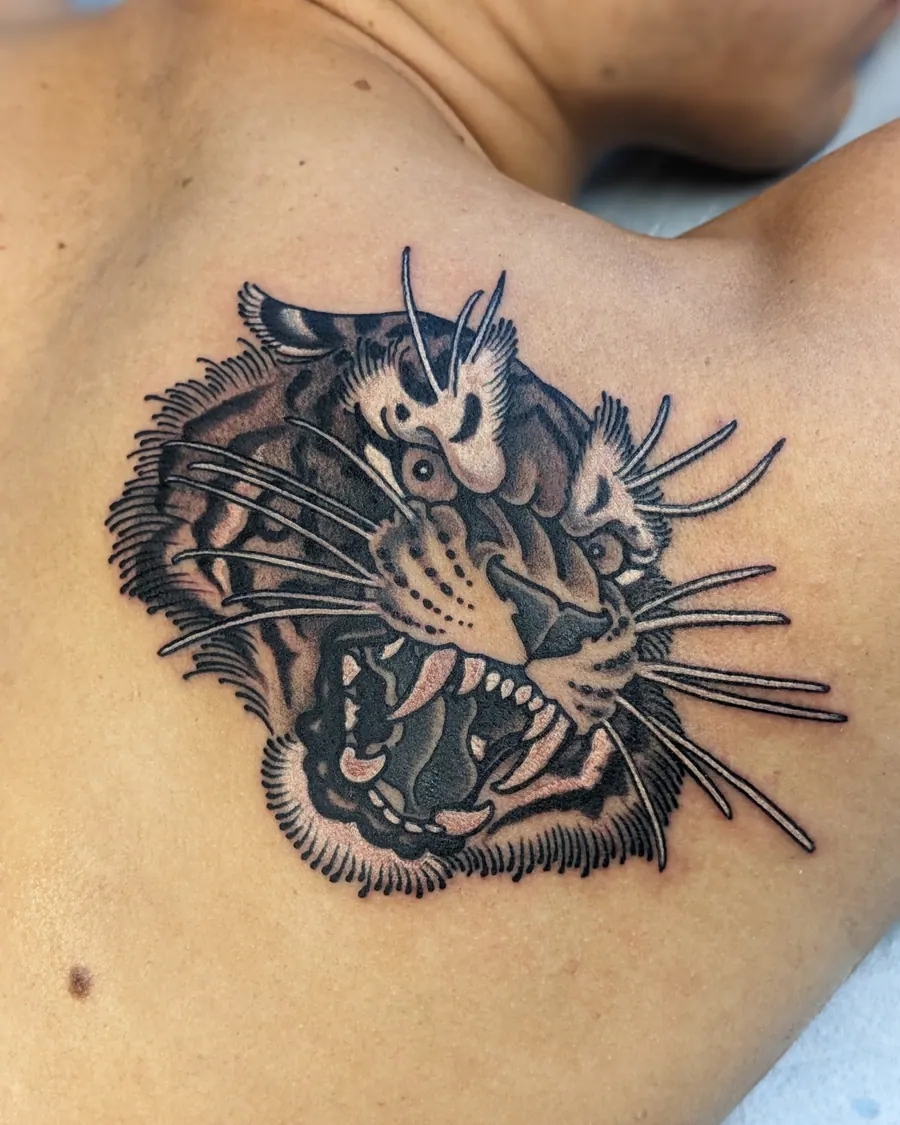 Black and gray roaring tiger head tattoo on the shoulder blade by English Cousins, Nashville